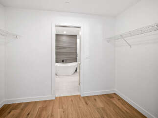 Step into this spacious walk-in closet, featuring ample shelving for all your storage needs.