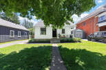 Charming white cottage-style home with a welcoming front porch, perfect for enjoying the outdoors.