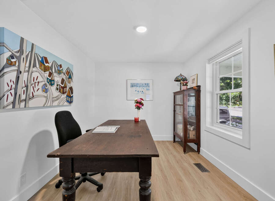 This home office features a rustic wooden desk paired with a comfortable black office chair, perfect for productivity.