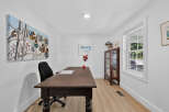 This home office features a rustic wooden desk paired with a comfortable black office chair, perfect for productivity.