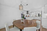This bright and airy dining area seamlessly transitions into a modern white kitchen, perfect for entertaining.