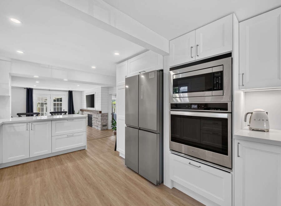 Experience modern living in this stunning kitchen featuring sleek white cabinetry, stainless steel appliances, and a spacious island perfect for meal prep and entertaining.