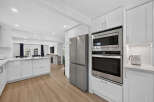 Experience modern living in this stunning kitchen featuring sleek white cabinetry, stainless steel appliances, and a spacious island perfect for meal prep and entertaining.