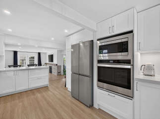Experience modern living in this stunning kitchen featuring sleek white cabinetry, stainless steel appliances, and a spacious island perfect for meal prep and entertaining.