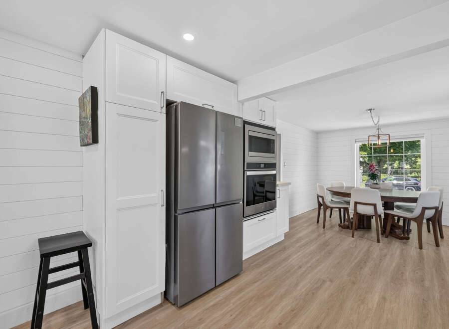 This modern kitchen features sleek stainless steel appliances, including a French door refrigerator and built-in oven and microwave.