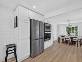 This modern kitchen features sleek stainless steel appliances, including a French door refrigerator and built-in oven and microwave.