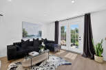 Step into this modern living room featuring a plush black sectional sofa adorned with velvet pillows, perfect for cozy evenings.