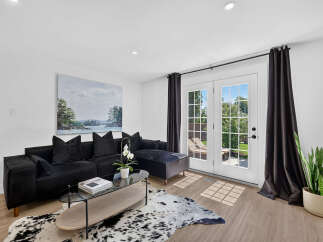 Step into this modern living room featuring a plush black sectional sofa adorned with velvet pillows, perfect for cozy evenings.