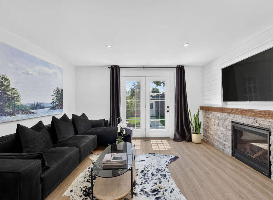 Step into this inviting living room featuring a spacious black sectional sofa perfect for relaxation and entertaining.