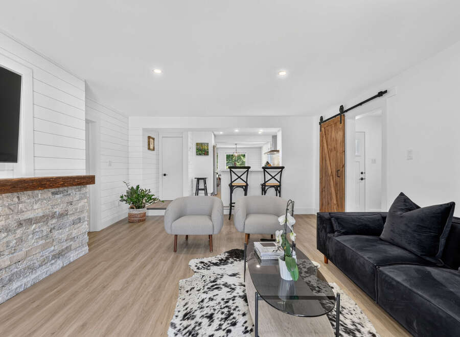 Experience modern living in this beautifully renovated home featuring a stunning stone fireplace and shiplap accent walls.