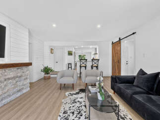 Experience modern living in this beautifully renovated home featuring a stunning stone fireplace and shiplap accent walls.
