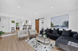 Experience modern living in this beautifully appointed living room, featuring a plush black sectional sofa perfect for relaxation and entertaining.