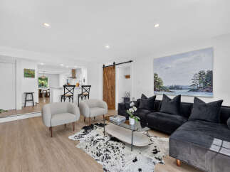 Experience modern living in this beautifully appointed living room, featuring a plush black sectional sofa perfect for relaxation and entertaining.