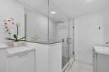 Experience modern luxury in this stunning bathroom featuring a spacious glass-enclosed shower with a rainfall showerhead and sleek tilework.
