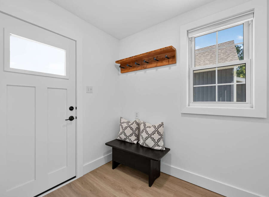 Step into this inviting entryway, featuring a sleek white door with a modern window panel.