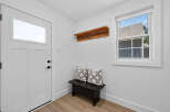 Step into this inviting entryway, featuring a sleek white door with a modern window panel.