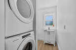 Discover modern convenience in this bright laundry area, featuring a stacked Amana washer and dryer for space-saving efficiency.