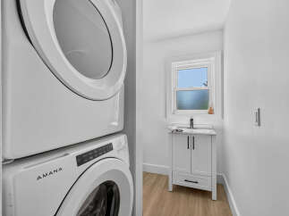Discover modern convenience in this bright laundry area, featuring a stacked Amana washer and dryer for space-saving efficiency.