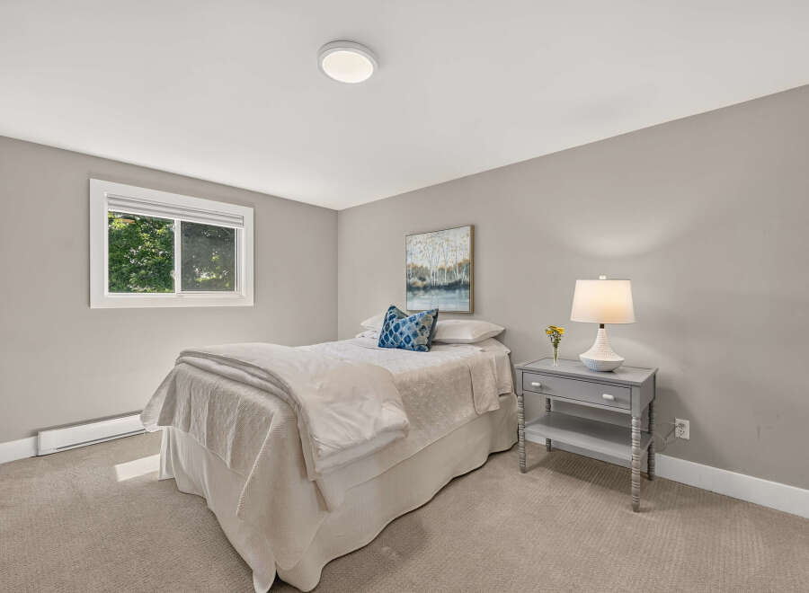 This cozy bedroom features a comfortable bed with crisp white linens and a decorative blue accent pillow.