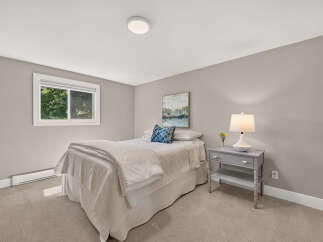 This cozy bedroom features a comfortable bed with crisp white linens and a decorative blue accent pillow.