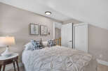 Discover comfort and style in this inviting bedroom, featuring a plush queen-size bed adorned with decorative pillows and a textured duvet.