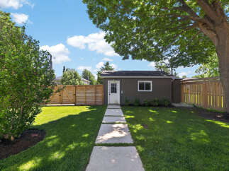 Discover this charming backyard oasis featuring a detached garage and a beautiful wooden fence.