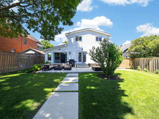 Enjoy outdoor living in this spacious backyard featuring a large patio with comfortable seating and a barbecue grill, perfect for entertaining.