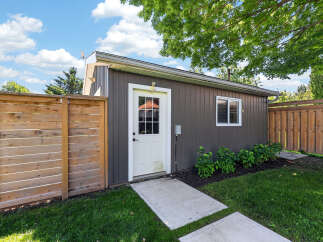 Discover this charming property featuring a well-maintained shed with a classic white door and a convenient window, perfect for storage or a workshop.