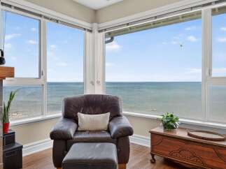 Enjoy breathtaking ocean views from this stunning living space, featuring a comfortable leather armchair and ottoman perfect for relaxation.