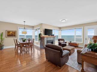 Experience breathtaking ocean views from this stunning living and dining area, featuring a cozy fireplace and ample natural light.