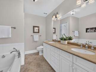 This spacious bathroom features a luxurious soaking tub and a double vanity with ample counter space.
