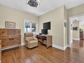 Step into this inviting room featuring a comfortable recliner and a media console with two televisions, perfect for entertainment.