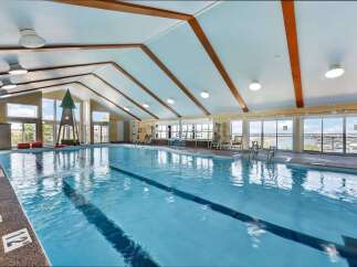 Dive into relaxation at this indoor swimming pool, featuring a spacious design with lap lanes for exercise and ample natural light from large windows.