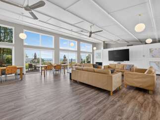Experience breathtaking ocean views from this spacious common area, featuring ample seating and large windows.