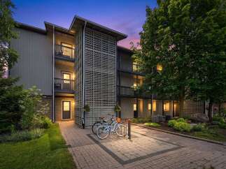 Experience modern living in this charming apartment complex, featuring a unique lattice facade and private balconies perfect for enjoying the twilight sky.