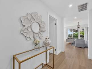 Step into this elegant entryway featuring a decorative floral mirror and a sleek console table.