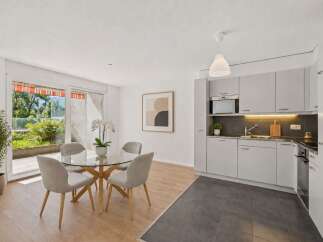 This modern apartment features a bright and airy dining area with a glass-top table and four upholstered chairs, perfect for intimate meals.