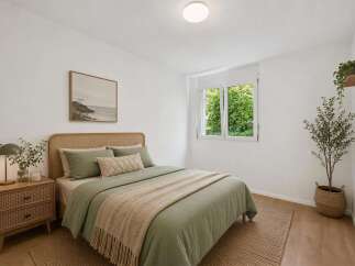 Experience serene living in this beautifully appointed bedroom, featuring a comfortable bed with calming green linens and a textured throw.