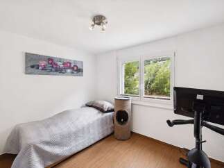 This room offers a comfortable single bed with a textured grey quilt, perfect for relaxation.