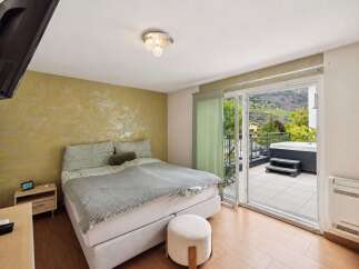 Experience ultimate relaxation in this stunning bedroom featuring a luxurious king-size bed and direct access to a private balcony with a hot tub.