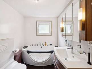 Experience ultimate relaxation in this luxurious bathroom featuring a spacious jacuzzi tub, perfect for unwinding after a long day.