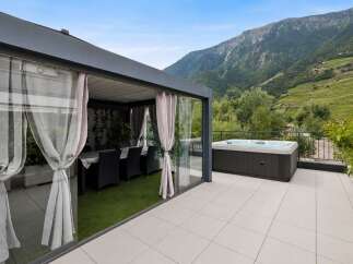 Experience luxury living with this stunning property featuring a spacious outdoor patio with a relaxing hot tub, perfect for unwinding while enjoying breathtaking mountain views.