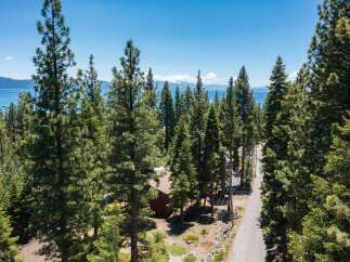 Nestled amidst towering pine trees, this property offers a serene escape with stunning lake views.