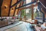 Experience rustic charm in this A-frame cabin living room, featuring a plush sectional sofa and a rustic wood coffee table.