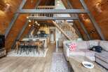 Experience rustic charm in this A-frame cabin featuring a spacious open-concept living area with a dining space and modern kitchen.