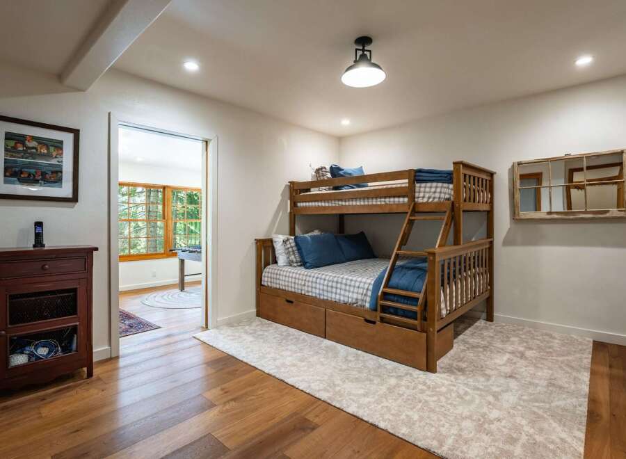 This charming bedroom features a sturdy wooden bunk bed with built-in drawers, perfect for maximizing space and storage.