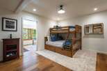 This charming bedroom features a sturdy wooden bunk bed with built-in drawers, perfect for maximizing space and storage.