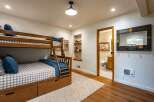 This charming bedroom features a sturdy wooden bunk bed with built-in drawers, perfect for maximizing space and accommodating guests.