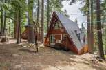 Experience the unique charm of this A-frame cabin nestled amongst tall pine trees.