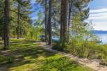 Enjoy serene lakefront living with this stunning property, featuring a lush green lawn perfect for outdoor activities and a scenic path leading to the water.